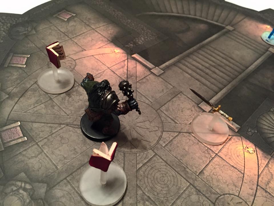 An orc deals with a flying sword and a pair of flying books inside the wizard's tower.
