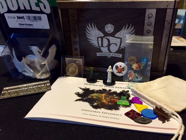 May's box from Dungeon Crate features two adventures, two sets of tokens, several miniatures and a coin.